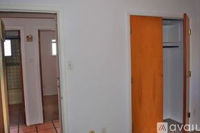 Santa Fe apartment for rent - A room with a white wall and a brown door.