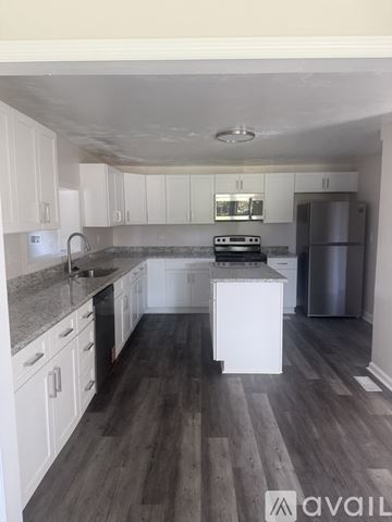 Chesapeake house for rent - A kitchen with white cabinets and a wooden floor.