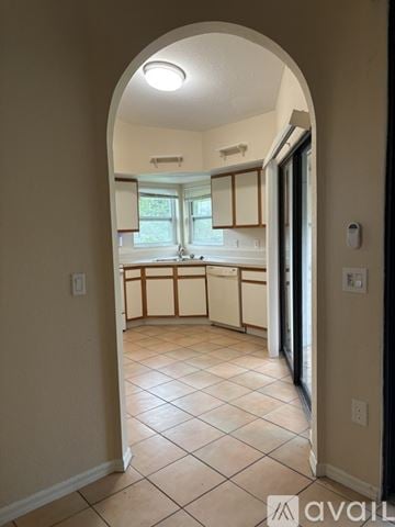 Punta Gorda apartment for rent - A hallway with a tiled floor and an archway leading to a kitchen.