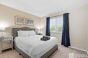 Dallas house for rent - A bedroom with a large bed and a window with blue curtains.
