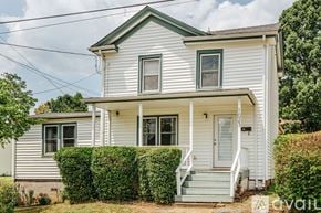 Charlottesville house for rent - A white house with a green roof and a hedge in front.