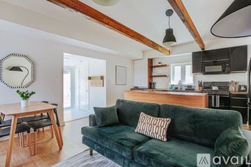 Charlottesville house for rent - A living room with a green couch and a wooden dining table.