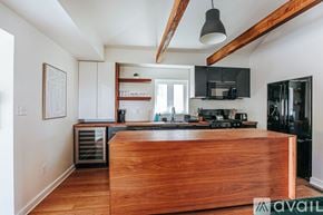 Charlottesville house for rent - A kitchen with a wooden counter top and black appliances.