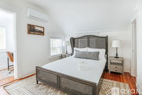 Charlottesville house for rent - A bedroom with a large bed and a painting on the wall.