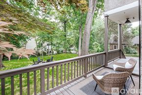 Charlottesville house for rent - A patio with a table and chairs overlooking a green lawn.