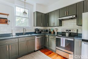 Charlottesville house for rent - A kitchen with dark green cabinets and stainless steel appliances.