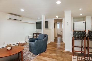 Charlottesville apartment for rent - A living room with a blue chair and a wooden table.