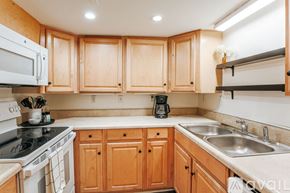 Charlottesville apartment for rent - A kitchen with wooden cabinets and a white stove.