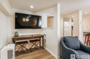 Charlottesville apartment for rent - A living room with a television, a desk, and a chair.