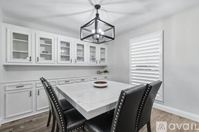 Flower Mound house for rent - A dining room with a table set for two and a chandelier hanging from the ceiling.