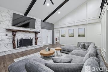 Flower Mound house for rent - A living room with a grey couch and a fireplace.