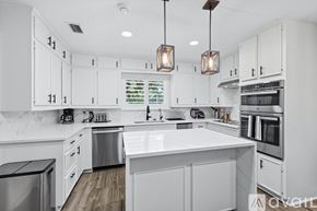 Flower Mound house for rent - A modern kitchen with white cabinets and a large island.