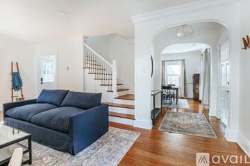 Charlottesville apartment for rent - A living room with a blue couch and a glass table.