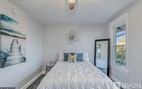 Washington townhouse for rent - A bedroom with a large bed and a painting on the wall.