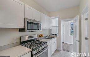 Washington townhouse for rent - A kitchen with white cabinets and a stainless steel stove top.