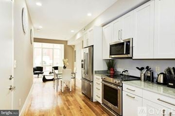 Washington apartment for rent - A modern kitchen with white cabinets and stainless steel appliances.