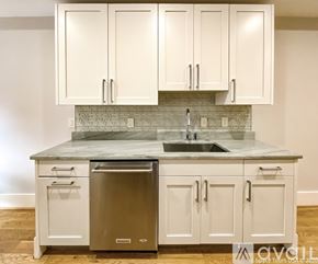 Washington apartment for rent - A kitchen with white cabinets and a marble countertop.