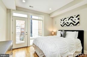 Washington apartment for rent - A bedroom with a large bed and a view of the outside.
