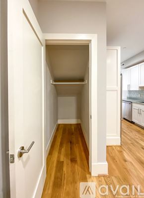 Washington apartment for rent - A hallway with a door on the left and a kitchen in the background.