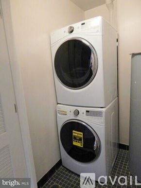Washington apartment for rent - A white washer and dryer stacked on top of each other in a small room.