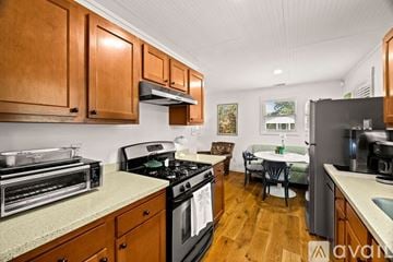 Savannah house for rent - A kitchen with wooden cabinets and a black stove top.