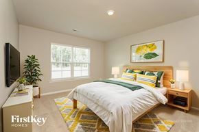 Lexington house for rent - A bedroom with a bed, a television, and a potted plant.