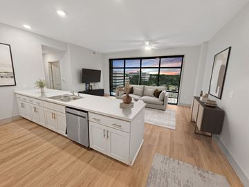 Jacksonville apartment for rent - A modern kitchen with white cabinets and a wooden floor.