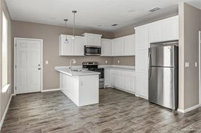 Weslaco apartment for rent - A kitchen with white cabinets and a wooden floor.