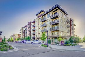 Sandy apartment for rent - Apartment building with cars parked in front.