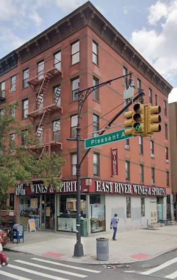 New York apartment for rent - A street corner with a traffic light and a building with a sign that says East River Wines & Spirits.