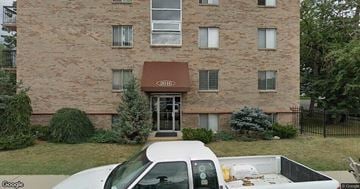 Calgary apartment for rent - A white truck is parked in front of a brick building.
