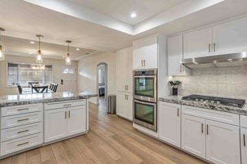 Santa Clara house for rent - A kitchen with white cabinets and a marble countertop.