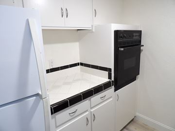 Dallas apartment for rent - A kitchen with white cabinets and a black and white tiled backsplash.