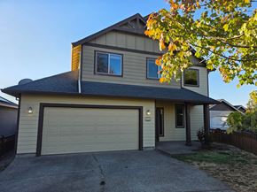 Dallas house for rent - A house with a garage and a tree with yellow leaves in front.