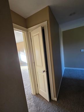 Dallas house for rent - A white door is open in a room with brown walls.