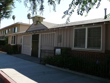 Van Nuys apartment for rent - A building with a brown roof and a sign on it.