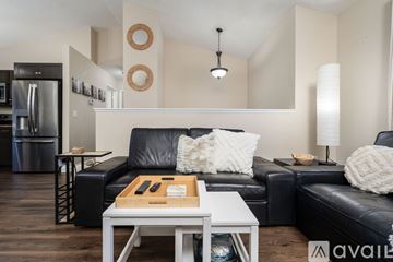 Johnson City house for rent - A modern living room with a black leather couch and a white coffee table.