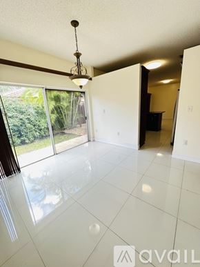 Doral house for rent - A bedroom with a large bed and a refrigerator in the corner.