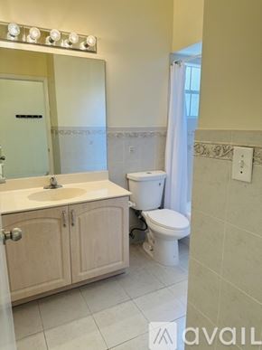 Doral house for rent - A patio area with a tiled floor and a variety of plants and trees.