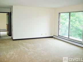 Coon Rapids apartment for rent - A room with a carpeted floor and a window overlooking a fence.