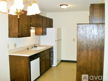 Coon Rapids apartment for rent - A kitchen with wooden cabinets and a white dishwasher.