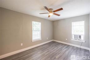 Houston apartment for rent - A room with a ceiling fan and two windows.