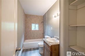Houston apartment for rent - A bathroom with a tub, toilet, and sink.
