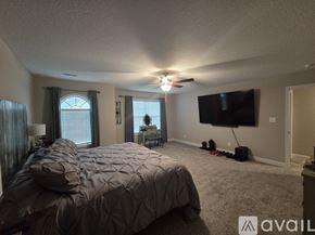 Knoxville house for rent - A bedroom with a large bed and a flat screen TV mounted on the wall.