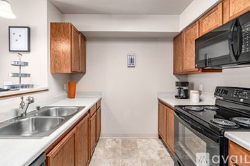 Airway Heights apartment for rent - A kitchen with wooden cabinets and a black microwave.