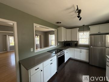 La Crosse house for rent - A kitchen with white cabinets and a stainless steel refrigerator.