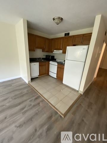 Boston apartment for rent - A kitchen with white appliances and wooden cabinets.