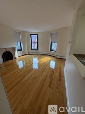 Boston apartment for rent - A room with wooden flooring and three windows.