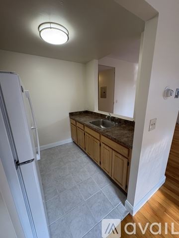 Boston apartment for rent - A kitchen with a white fridge and wooden cabinets.