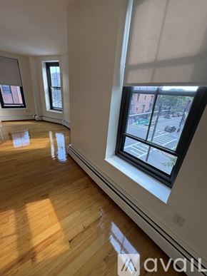 Boston apartment for rent - A room with wooden floors and three windows.